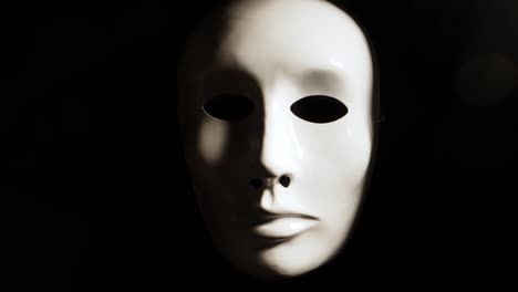 white face mask on dark background.