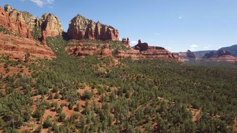 aerial descent from the famous red rock formation of sedona, arizona to a pinion pine forest.