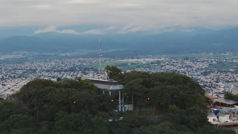 Ascending-Aerial-Reveals-Capital-City-Of-Salta-From-Behind-Mountain-Peak