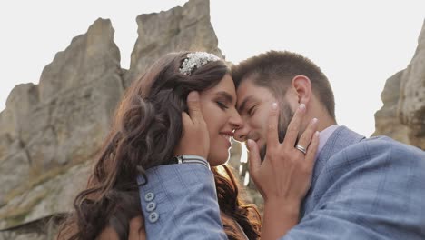 el novio con la novia cerca de las colinas de la montaña. pareja de bodas enamorada. rayos de sol