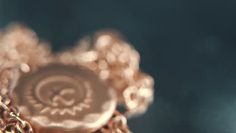 a detailed macro tilt down shot of a golden medallion necklace, flying bird in the middle of the sun symbol, on a rotating stand, mirror reflection, studio lighting, 4k video