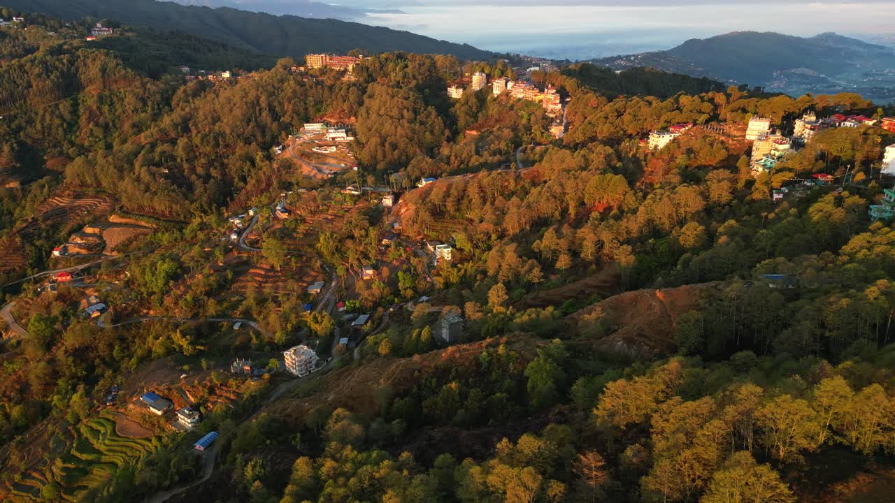Sunset golden hours rays cast over village homes on mountainside of Nepal