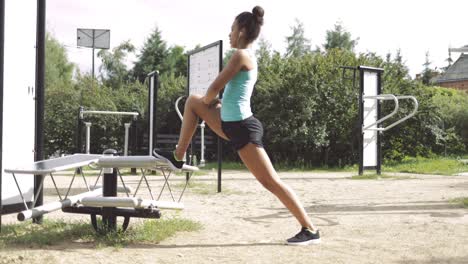 mujer deportiva que se extiende en el parque