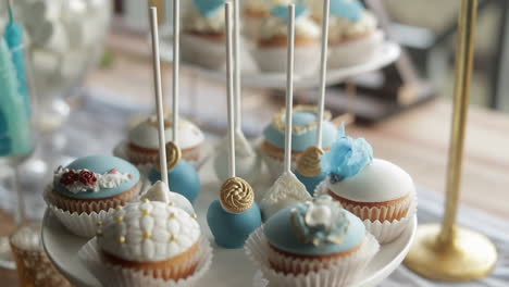 decorated cupcakes with blue, white - gold details, close up