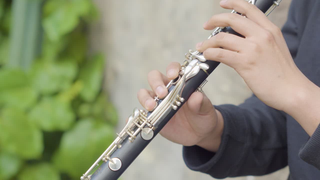 클라리넷 을 연주 하는 젊은 연주자 의 클로즈업  ⁇