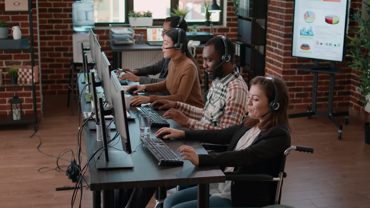Young woman in wheelchair helping clients at call center