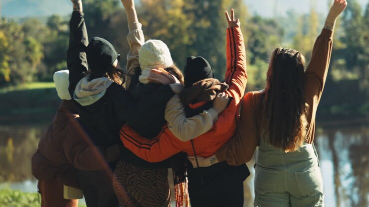 Mujeres, grupo y de espaldas con abrazo al aire libre