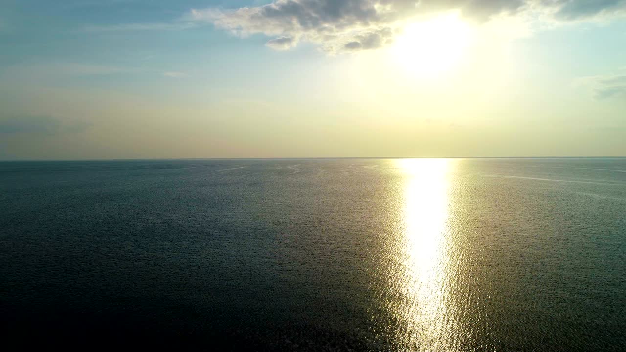 해가 지는 배경에서 바다 표면 위의 비행. 드로코프터