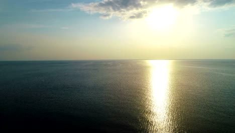 el vuelo sobre la superficie del mar en el fondo del atardecer. tiro de cuadrocóptero