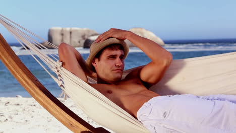 Man-relaxing-in-a-hammock-on-the-beach