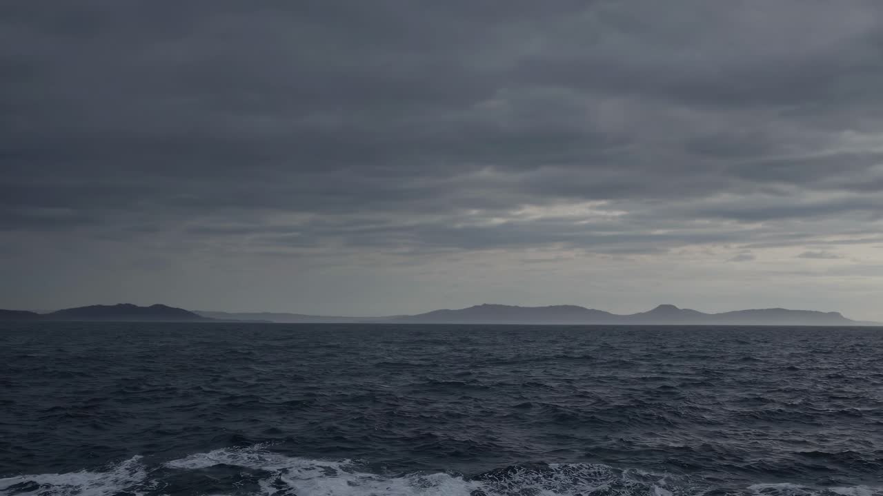 Dramatic seascape video with a wide-angle view, capturing dark clouds over a choppy ocean