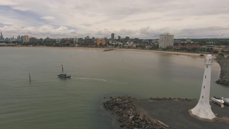 drone aerial by the st kilda lighthouse in melbourne with a boat on the water