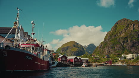 harbor view in reine, lofoten, norway. view of red wooden fishermen cabins, fishing boat and the picturesque nordic landscape.