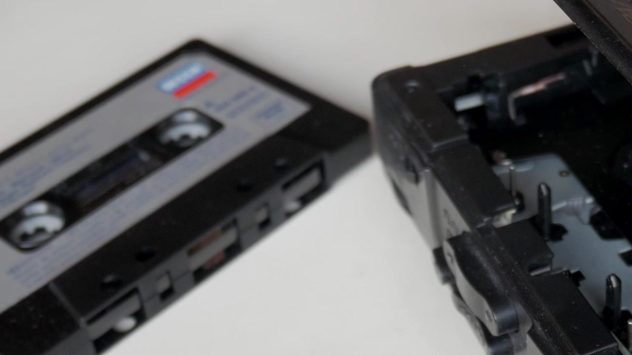 Beyaz arka plan üzerinde ses kasetinin yanında kaydırılan vintage kaset çalar kapağı