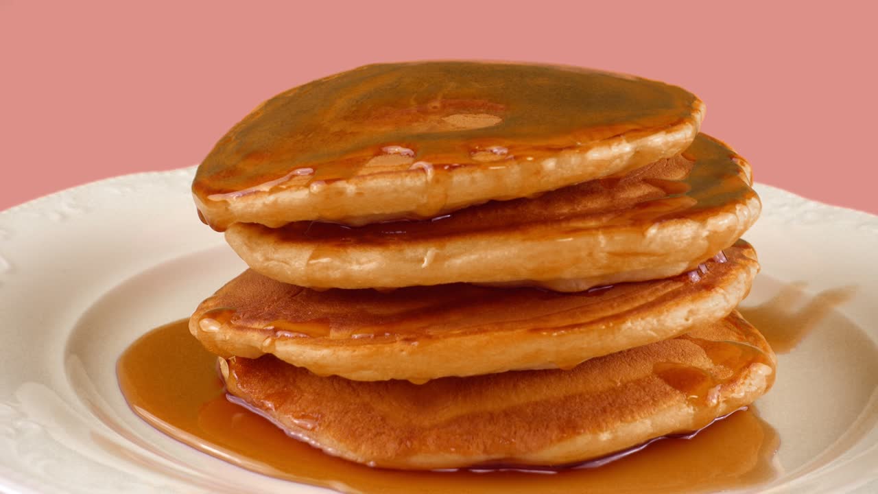 핑크색 배경에 메이플 시럽과 함께 미국 팬케이크.