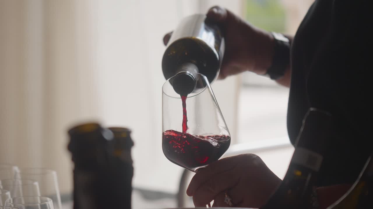 Pouring red wine into glass. A classy drink for formal and romantic occasions.