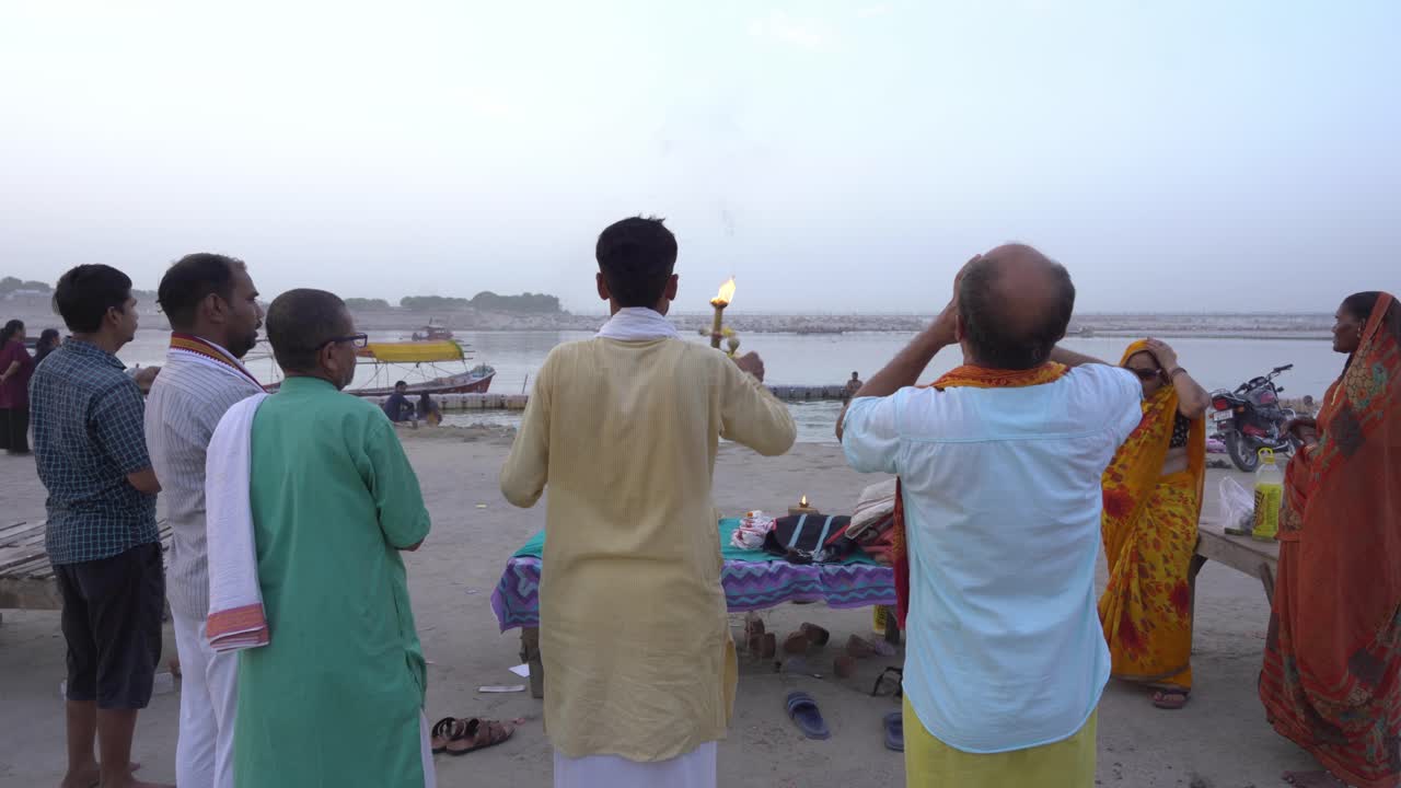 Hindu devotees performing a religious ritual on a riverbank