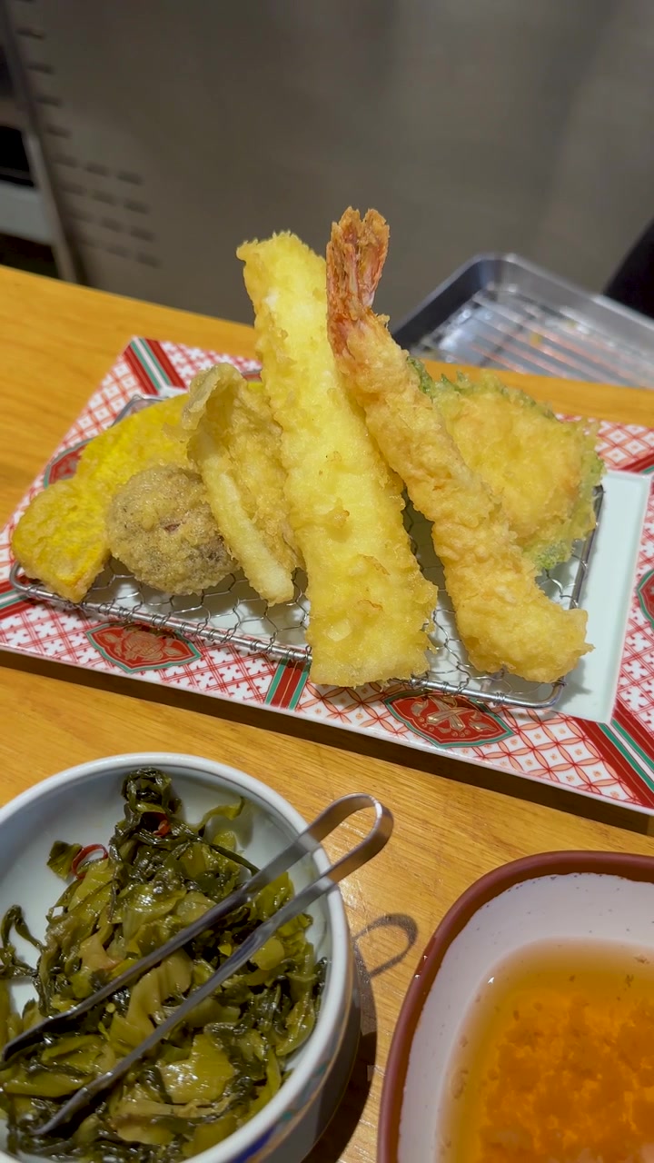 サービングトレイにサクサクの天ぷらを並べる人