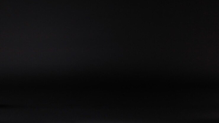 Tennis ball rolling across a dark surface