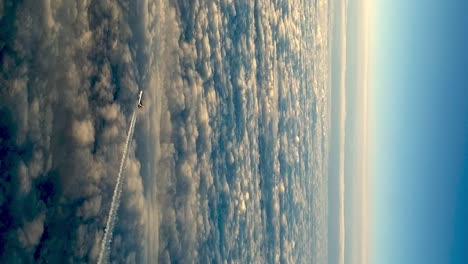 Flying-airplane-above-clouds-leaving-condensation-vapor-air-trail-in-blue-sky