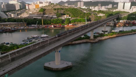 Establishing-crane-shot-of-MTR-train-on-the-Tung-Chung-line-from-Kwai-Chung-towards-Tsing-Yi-crossing-rail-bridge