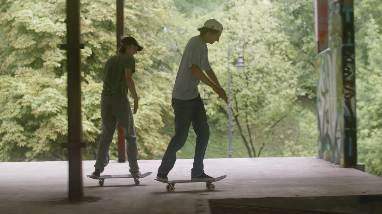 백인 소년들이 폐허가 된 건물에서 스케이트보드를 타고 있습니다.