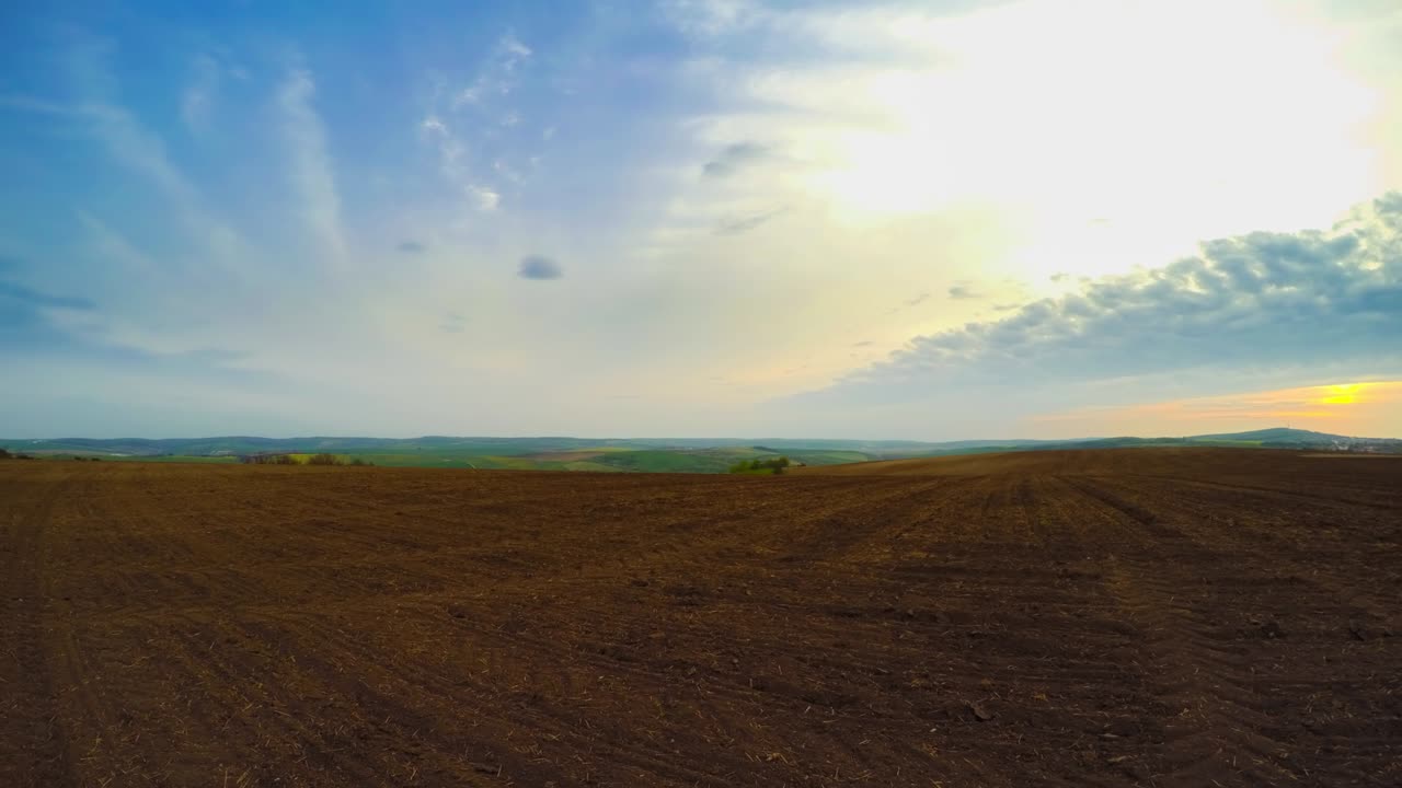 tierra arada y nubes. panorama. lapso de tiempo uhd