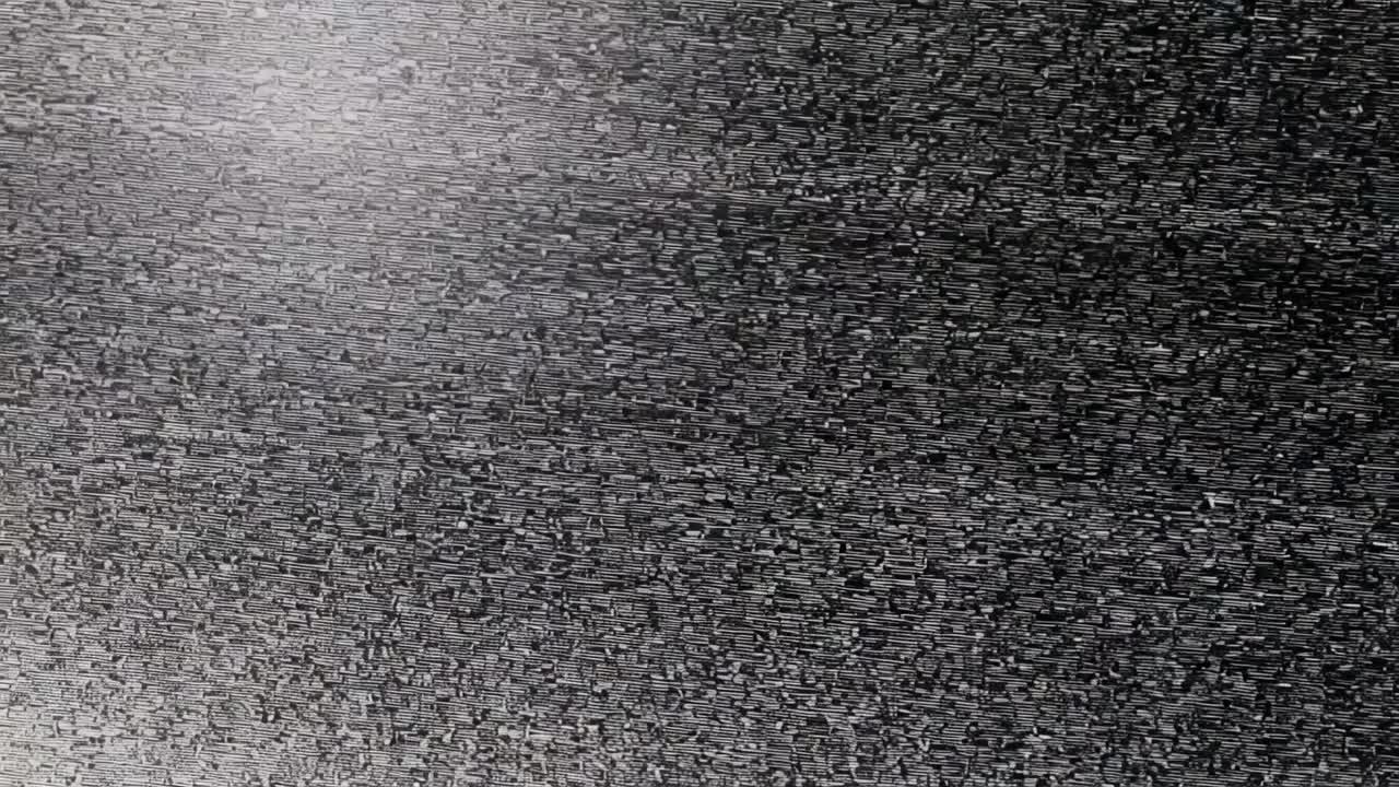 Schermo grigio statico e scintillante, con una macchia più chiara in alto a sinistra, che mostra il rumore del sensore