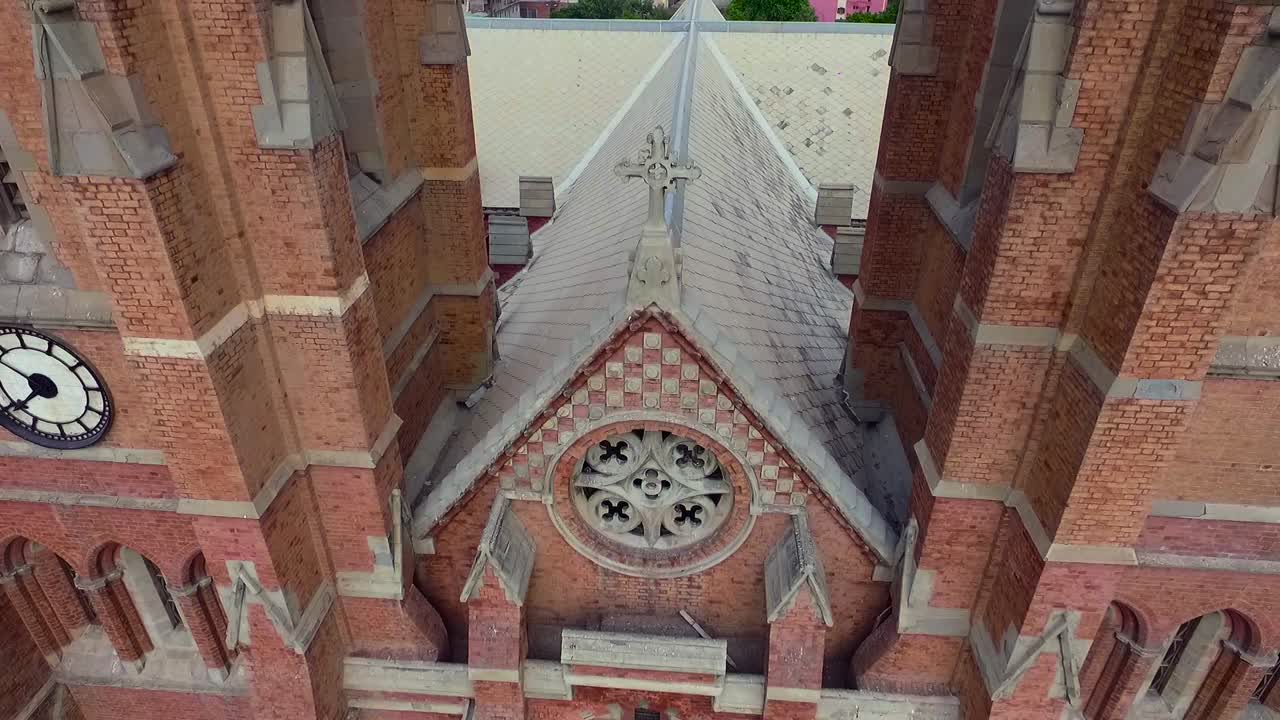 красивая старая церковь сверху крупным планом вид с воздуха, голубь пролетел над церковным крестом, часы на стене церкви