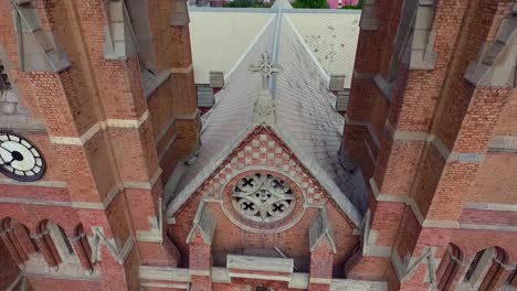 a beautiful old church top close up aerial view, a pigeon flew over the church cross, a clock on the wall of the church