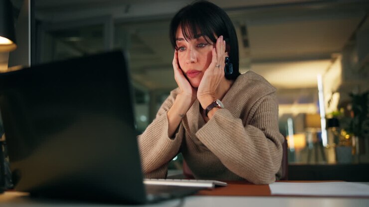 Woman working late at desk with laptop
