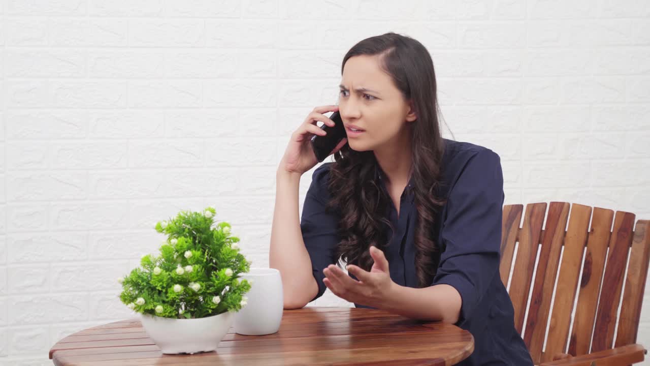 슬픈 인도 소녀가 전화로 이야기하고 있습니다.