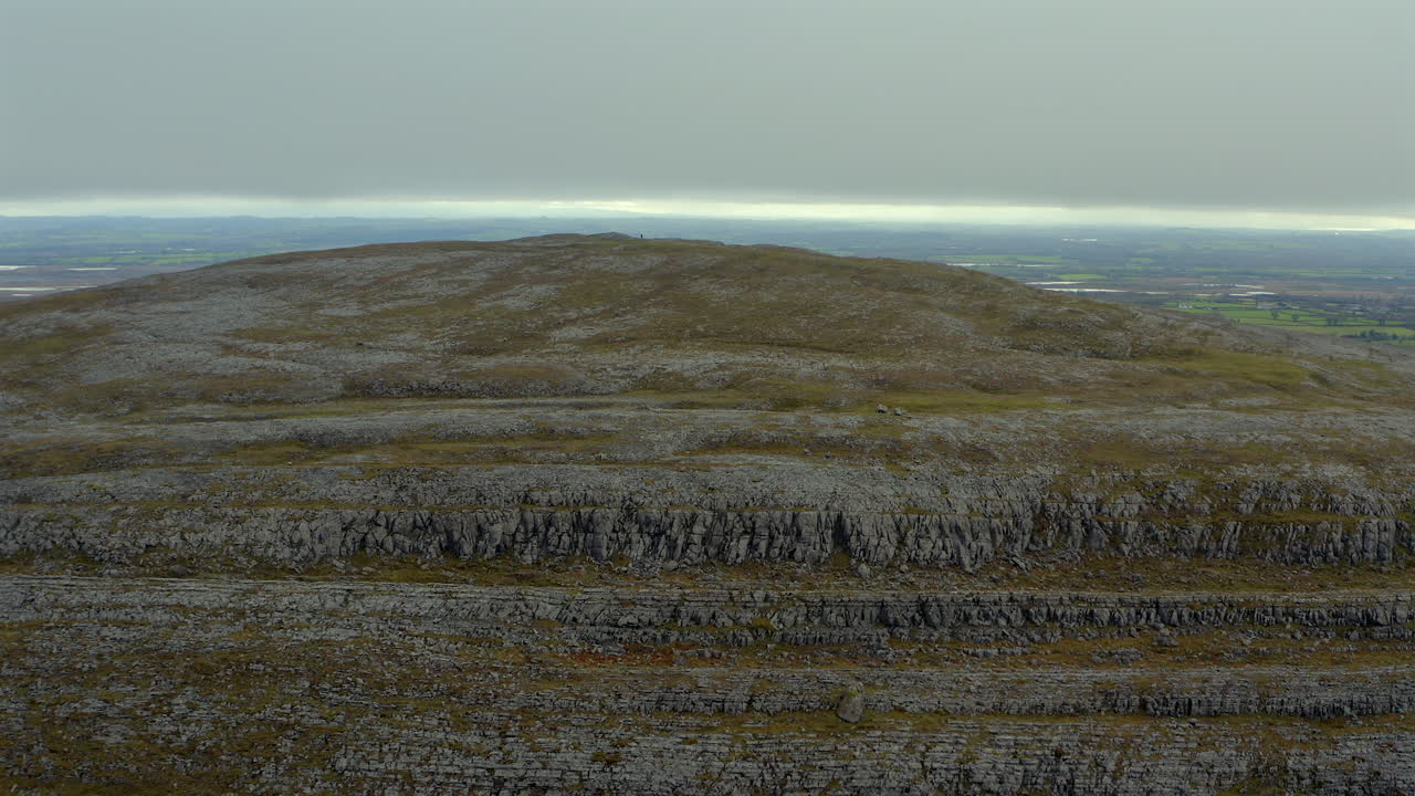 Circular aerial shot of Mullaghmore summit with mountaineers and stunning views. County Clare