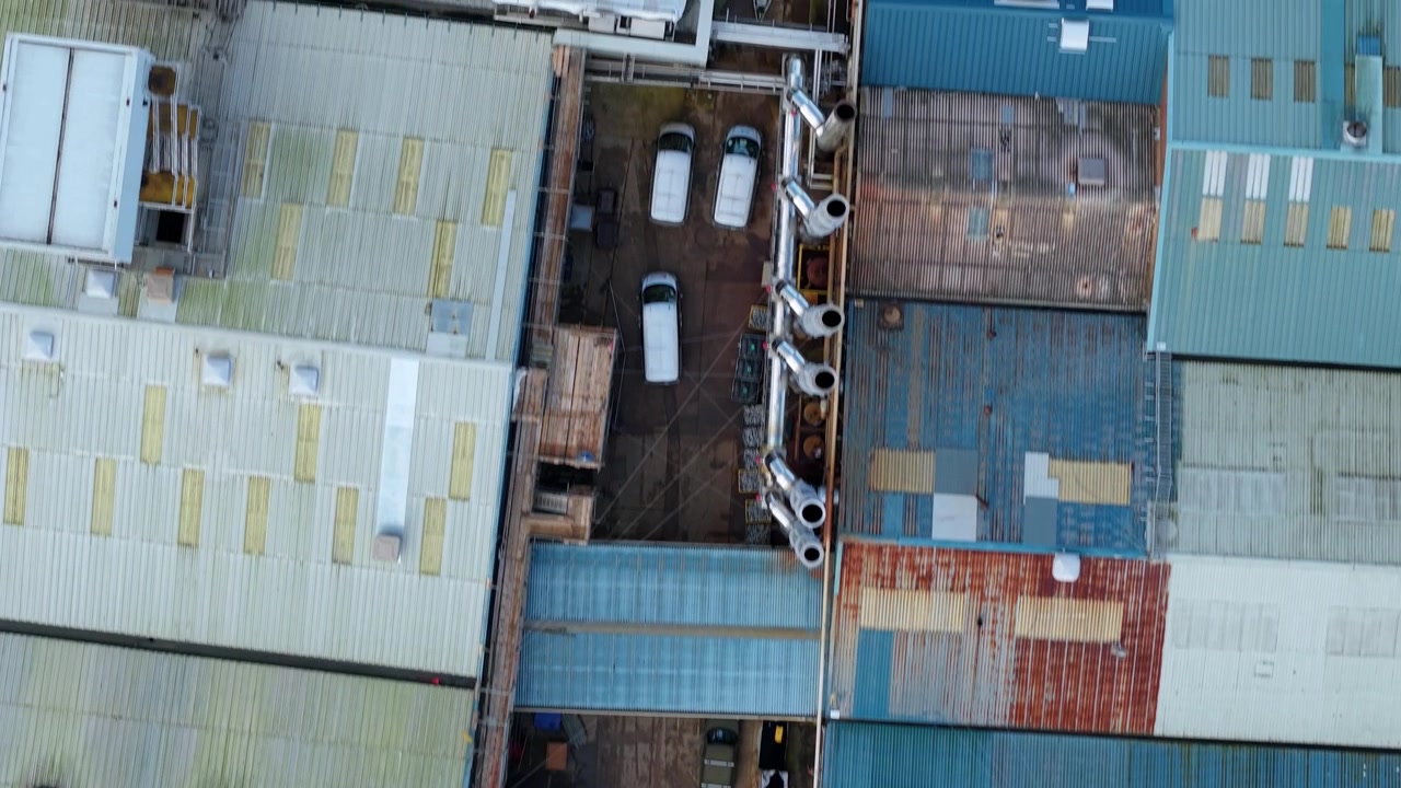 High angle drone view of commercial facility rooftops showcasing industrial HVAC cooling fans and air systems