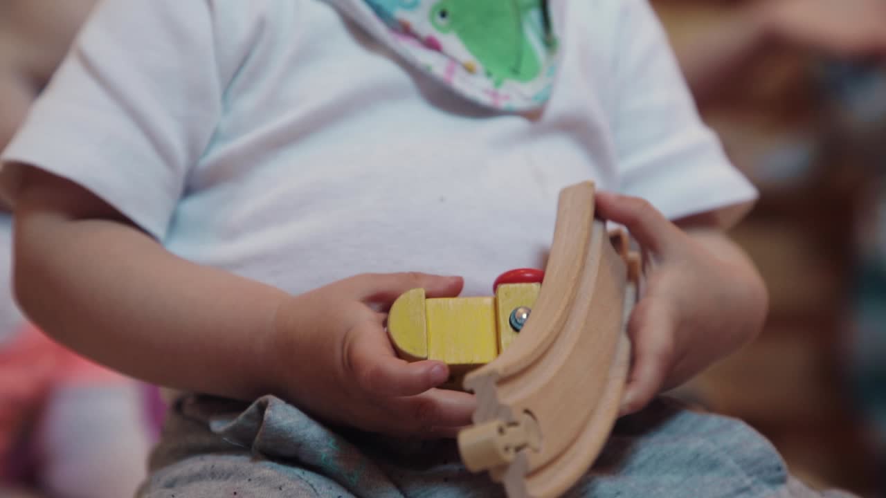 Child playing with wooden toy close up in kindergarten