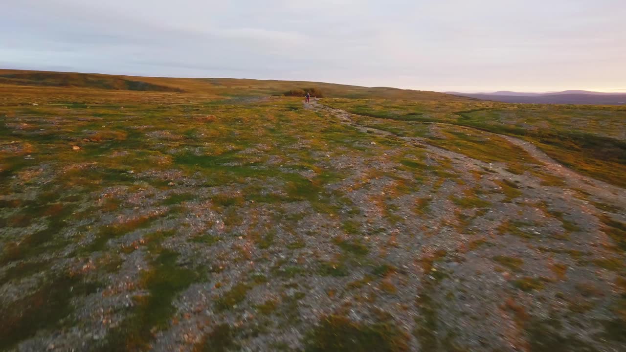 Very impressive aerial footage of Norwegian nature with people. Man standing on the path middle of nowhere with MTB bike. The arctic nature is very delicate. Nature reserves are very important.