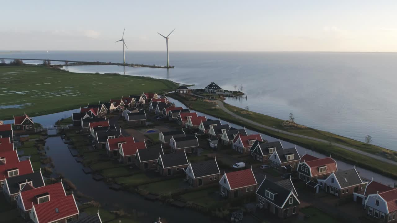 바다와 두 개의 풍차가 배경에 있는 작은 네덜란드 홀리데이 파크의 공중