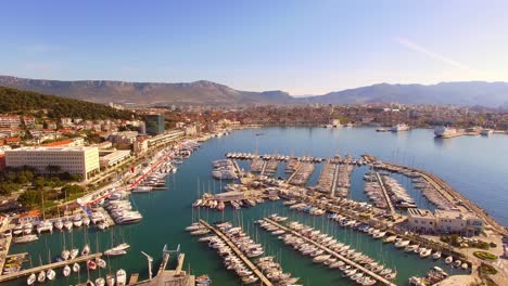 drone-flying-backwards-over-marine-full-of-yachts-in-Split-Croatia