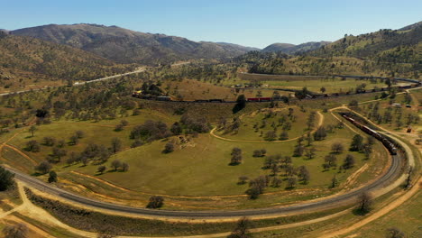 pull back aerial view of a train spiraling through the famous tehachapi loop