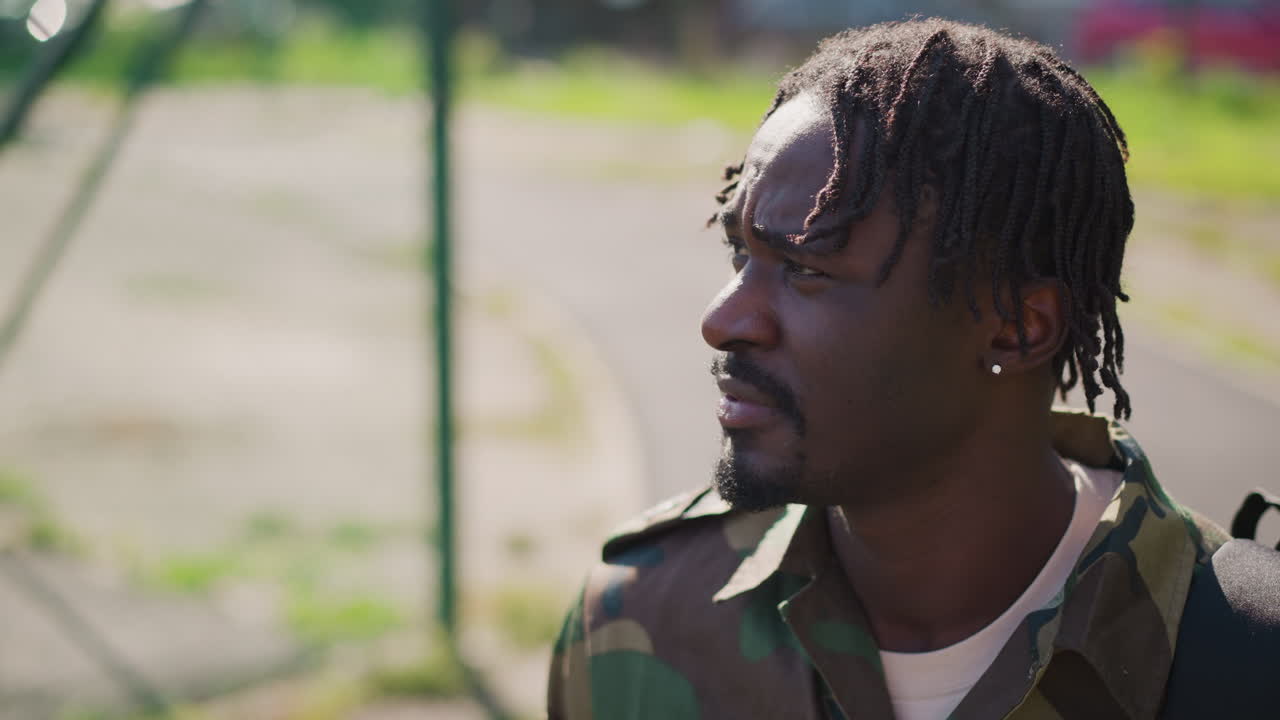 Veteran In Camouflage Pauses Thoughtfully Amid Suburban Pathway Scenery Today, Military Veteran Dressed In Camouflage Carefully Monitoring Quiet Suburban Streets During Late Afternoon Hours