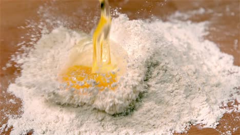 Egg-pouring-onto-flour-on-table