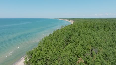 Aerial-establishing-view-of-Baltic-sea-beach-at-Jurkalne-on-a-sunny-summer-day,-white-sand-cliff-damaged-by-waves,-coastal-erosion,-climate-changes,-wide-drone-shot-moving-forward