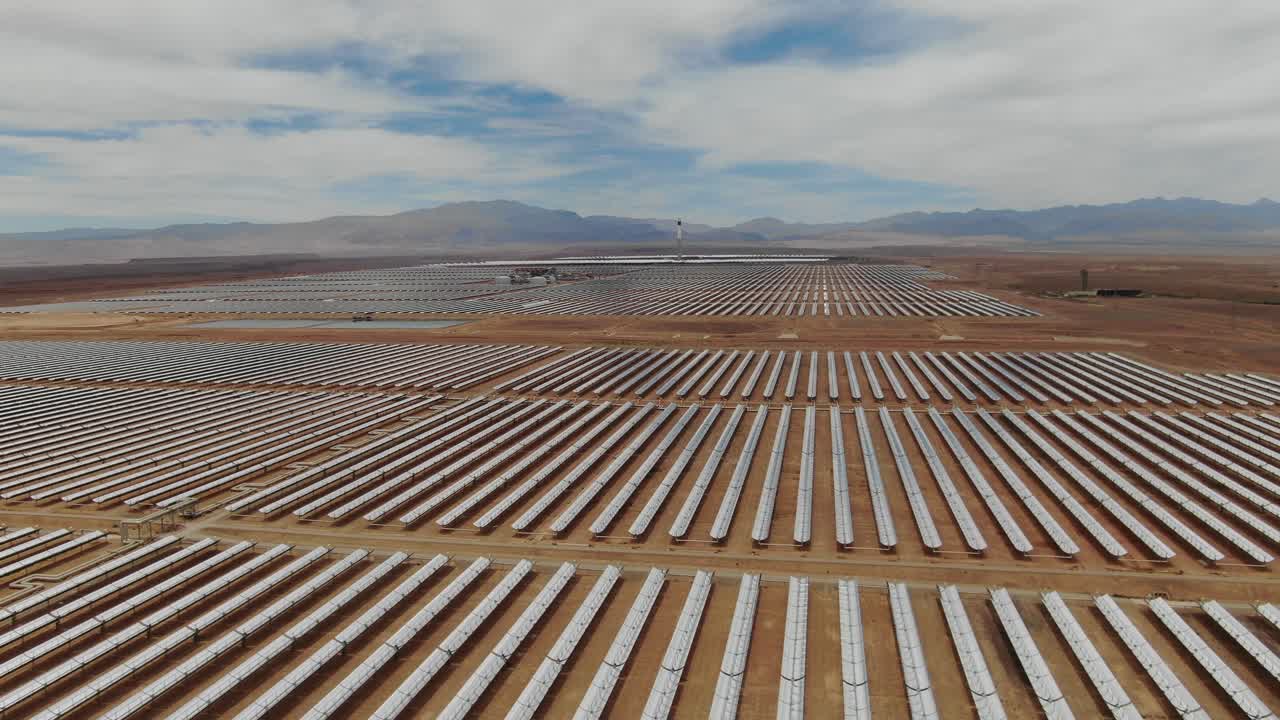 Luftfoto af lange rækker af solspejle, der strækker sig over Noor solenergikomplekset i Ouarzazate, Marokko, hvilket fremhæver storstilet vedvarende energi i ørkenen