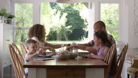 family at home eating meal in dining room together