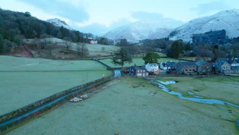 frosty fields and snowy mountains at dawn at the village of grasmere