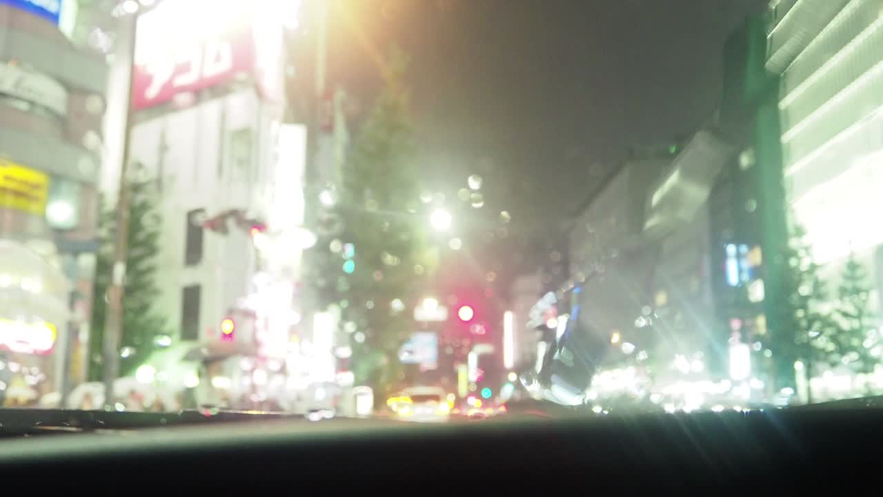 비가 내리는 도쿄 신주쿠의 교차로를 건너는 사람들