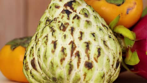 close-up view of cherimoya, persimmon, and dragon fruit