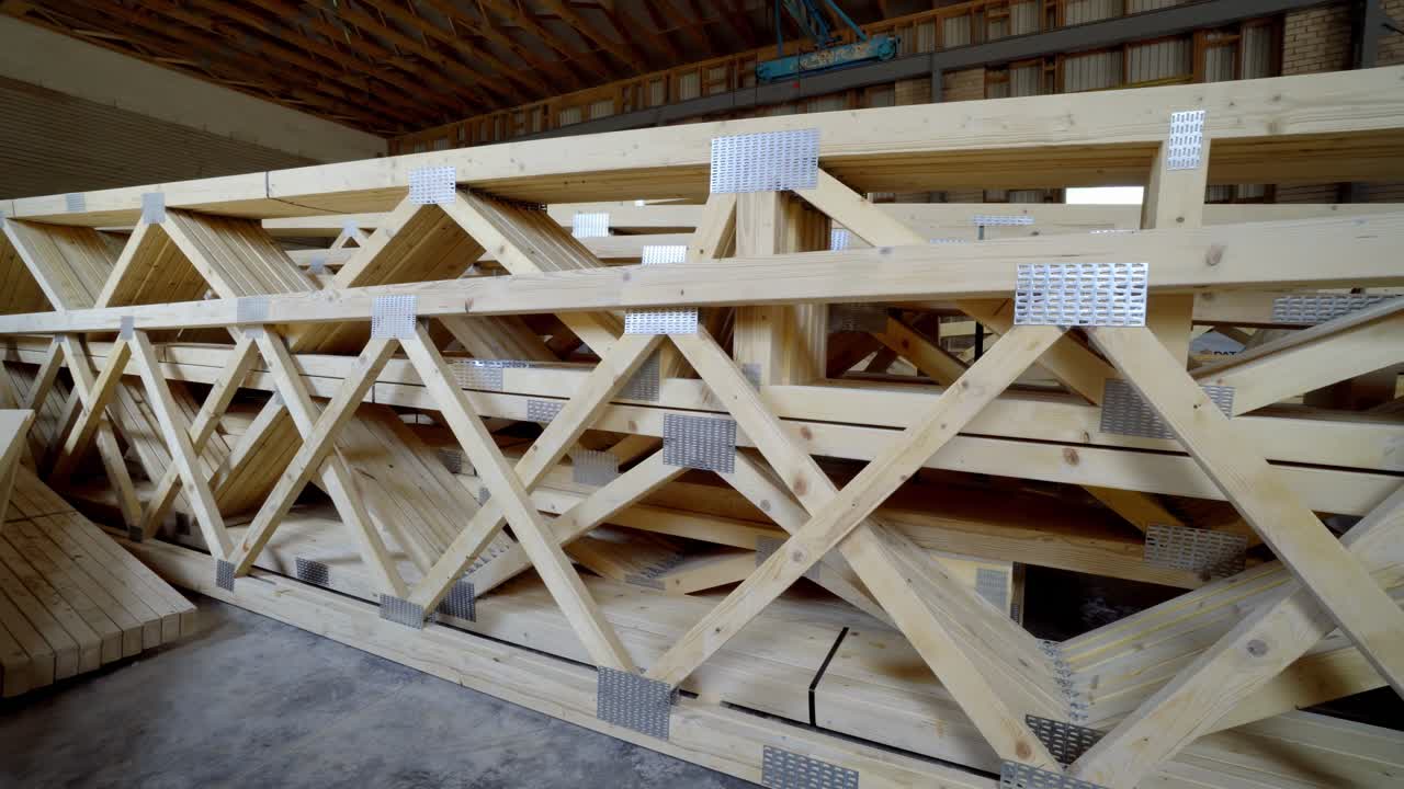 Wooden trusses stacked in a rustic workshop, showcasing construction materials