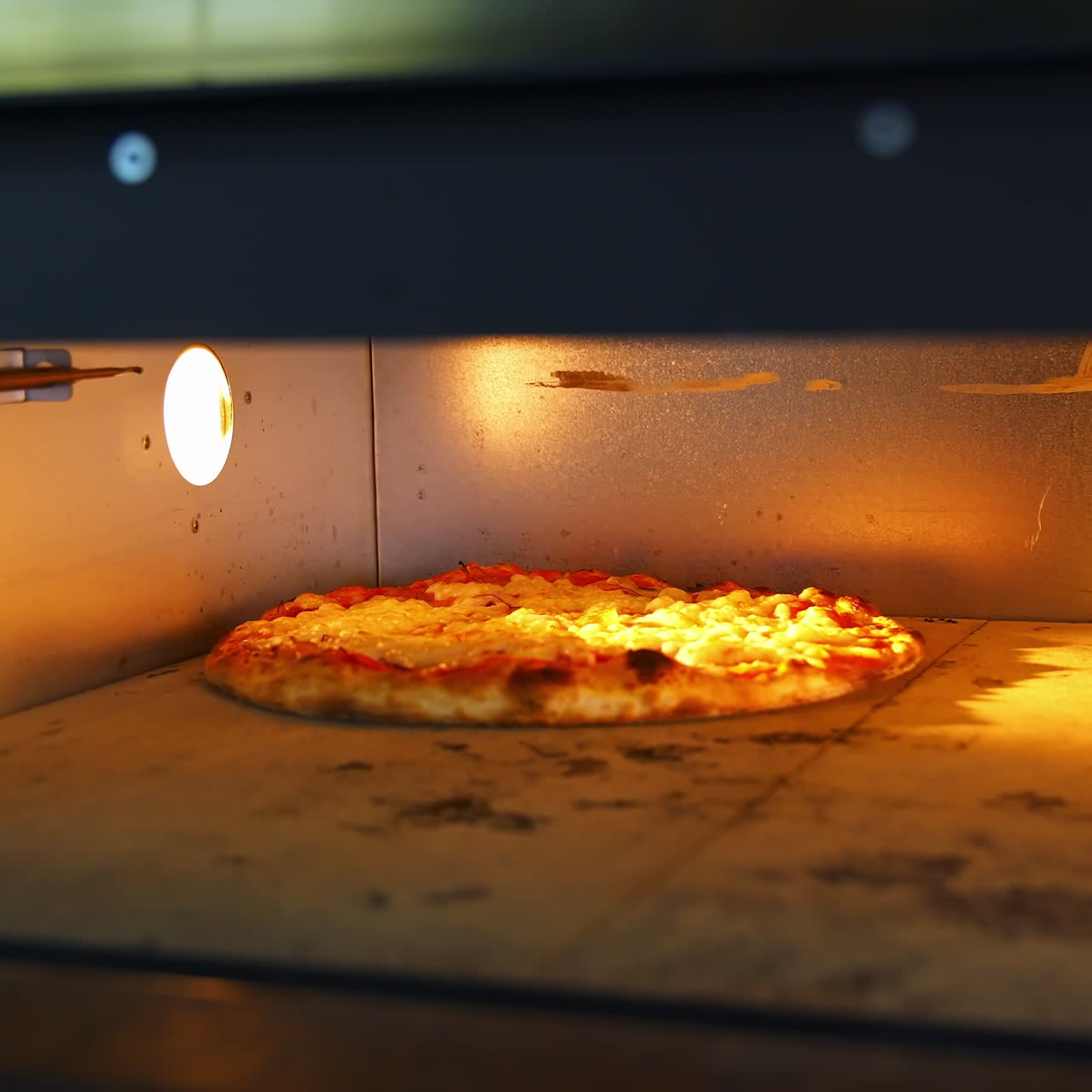 Deliziosa pizza nel forno caldo. Lo chef sta togliendo la pizza pronta con una pala speciale per pizza. Processo di cottura della pizza in pizzeria.