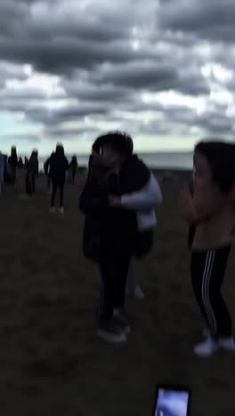 people on beach observing a flying object
